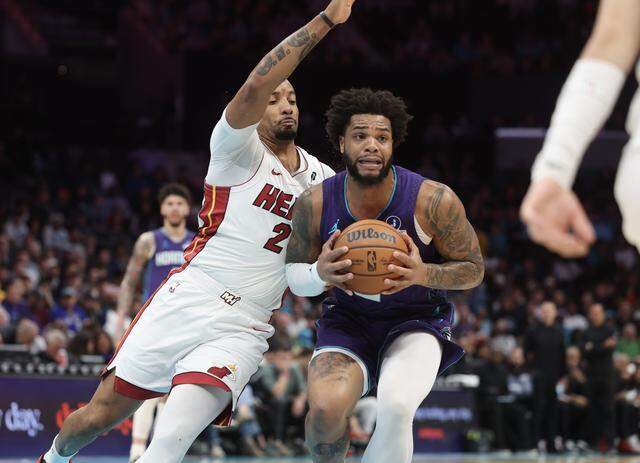 Charlotte Hornets forward Miles Bridges drives toward the basket as Miami Heat guard Terry Rozier defends Tuesday at Spectrum Center in Charlotte.